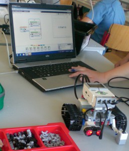 Lego Roboter mit Bausteinen und Programmieroberfläche.