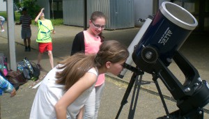 Schülerinnen beobachten, wie sich Merkur vor die Sonne schiebt.